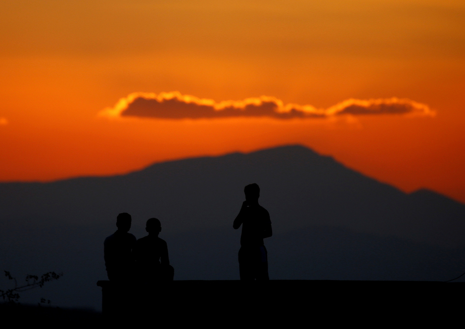 Boys watch atop the roof of their house on the Turkish-Syrian border line in Reyhanli, Hatay province, Turkey. PHOTO: REUTERS
