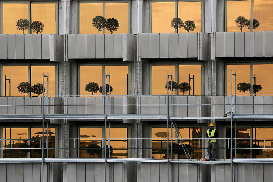 A worker stands on a scaffold set for repairing the facade of a hotel in Athens, Greece. PHOTO: REUTERS