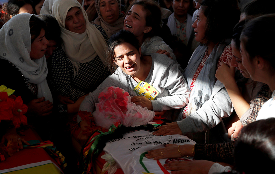 Mourners weep over the coffin of a Syrian journalist killed by the Islamic State militants on the frontline in Deir al-Zour, during a funeral in Kobani, Syria. PHOTO: REUTERS