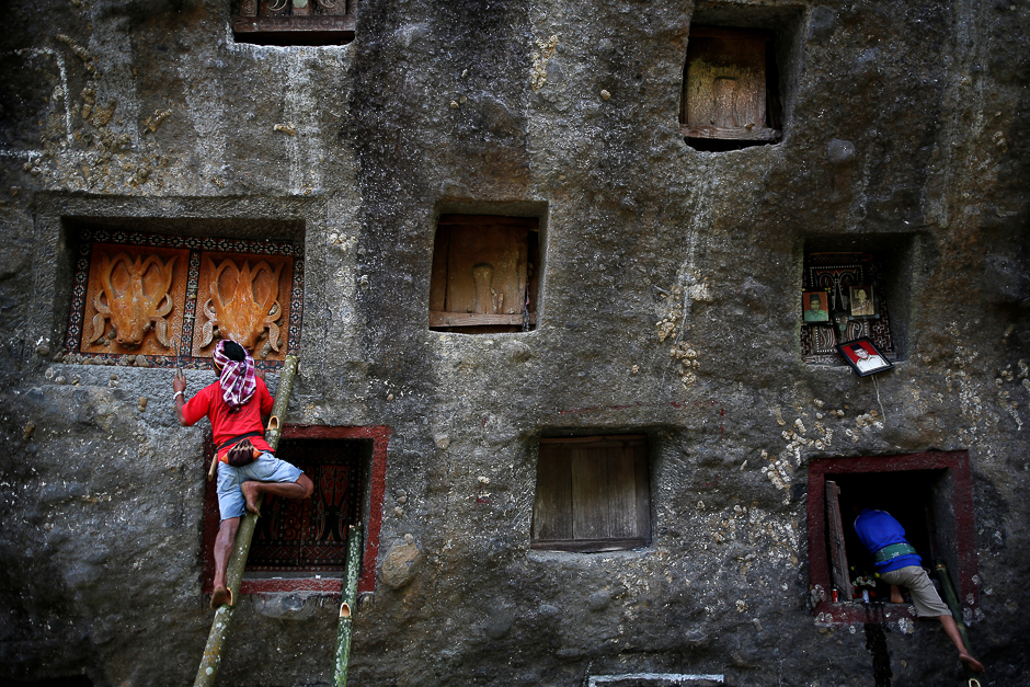 Men use bamboo ladders to open doors to burial chambers near Rantepao, North Toraja, South Sulawesi, Indonesia. PHOTO: REUTERS