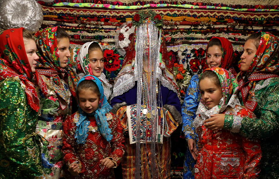 Bulgarian Muslim bride Dhzemile Lilova, 30, poses with friends and relatives in front of the dowry wearing a special make-up called 