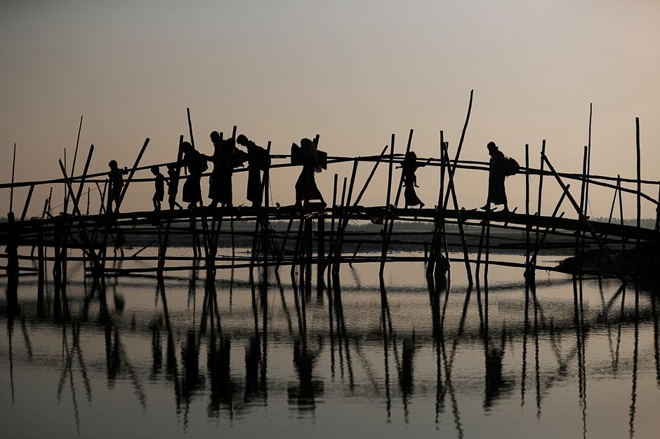 Rohingya refugees cross a bamboo bridge as they arrive at a port after crossing from Myanmar, in Teknaf, Bangladesh. PHOTO: REUTERS