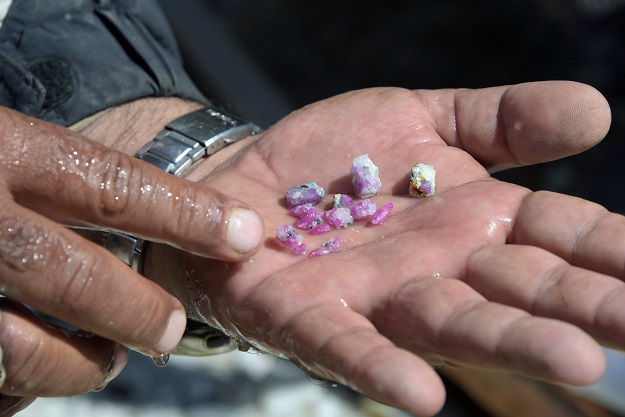 A Pakistani labourer displaying ruby gemstones after finding them in pieces of rocks outside a mine at a mountain in the Kashmiri town of Chitta Katha in Upper Neelum Valley. PHOTO: AFP