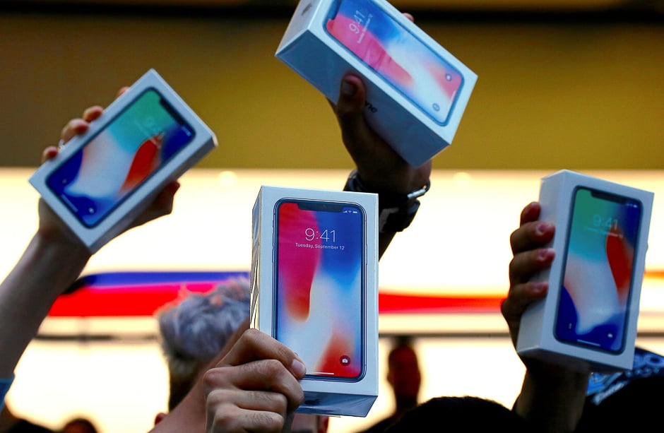 The first customers to buy the iPhone X hold it aloft during the global launch of the new Apple product in central Sydney, Australia. PHOTO: REUTERS