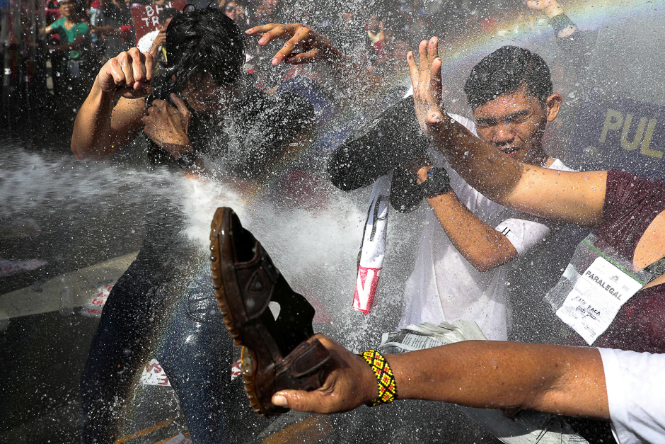 Protesters are hit by a water cannon as they try to march towards the US embassy during a rally against US President Donald Trump's visit, in Manila, Philippines. PHOTO: REUTERS