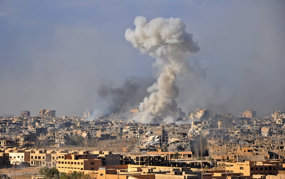 Smoke rises from buildings following an air strike by Syrian government forces in the eastern city of Deir Ezzor. PHOTO: AFP