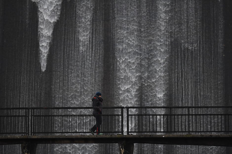 A walker crosses a bridge in front of overflow water cascading over the dam into the River Lowther at Wet Sleddale Reservoir just south of the village of Shap, in Cumbria, northern England. PHOTO: AFP