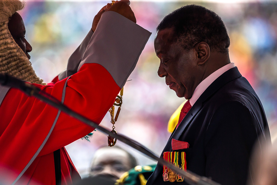 New interim Zimbabwean President Emmerson Mnangagwa receives the chain and sash of office as he is officially sworn-in during a ceremony in Harare. PHOTO: AFP