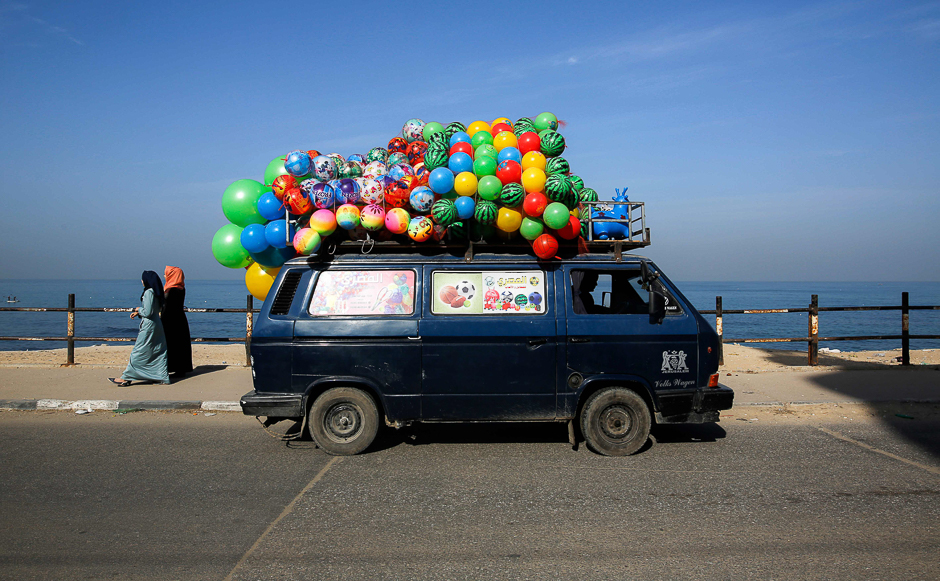 A minibus loaded with balloons drive along the coastal road by the beach in Gaza City. PHOTO: AFP