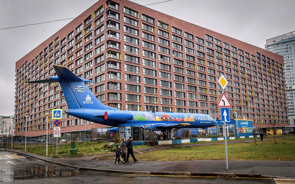 People pass a Tu-134B passenger aircraft parked outside an apartment building in Moscow. PHOTO: AFP