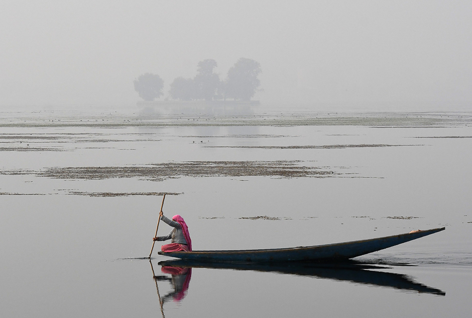 A Kashmiri resident rows a boat across dal Lake in Srinagar. PHOTO: AFP