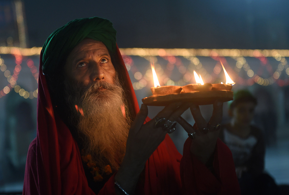 A Pakistani Sufi follower holds oil lamps at the Data Darbar complex, which contains the shrine of Saint Syed Ali bin Osman Al-Hajvery, during the three-day annual 'Urs' religious festival in Lahore. PHOTO: AFP