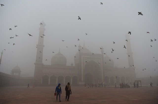 indian visitors walk through the courtyard of jama masjid amid heavy smog in the old quarters of new delhi photo afp