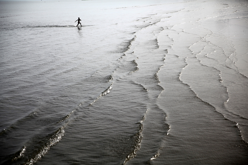 A boy runs in shallow water on a beach in the coastal city of Larnaca, Cyprus. PHOTO: REUTERS