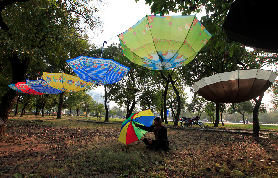 A man waits for customers while selling umbrellas along a roadside in Islamabad, Pakistan. PHOTO: REUTERS