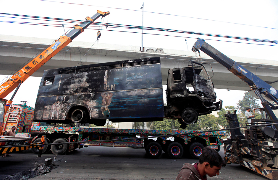A police prison van, destroyed during clashes, is cleared from the road a day after the Tehreek-e-Labaik Pakistan Islamist political party called off nationwide protests in Islamabad. PHOTO: REUTERS
