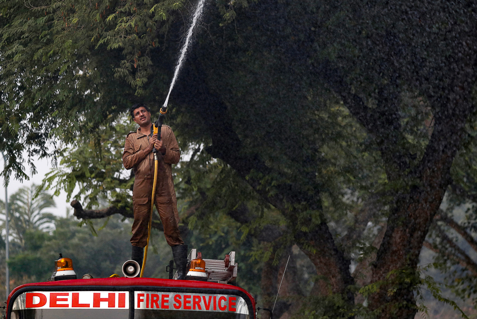 A firefighter sprays water onto trees to fight the air pollution in Delhi, India. PHOTO: REUTERS