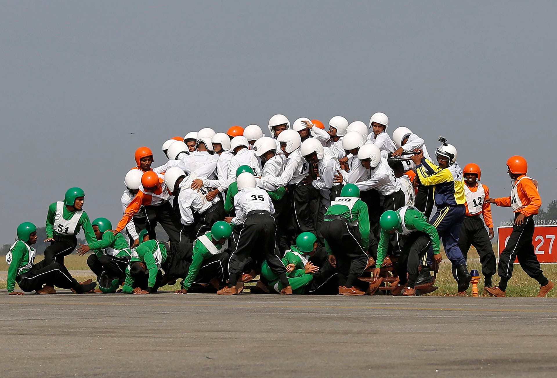 Members of the Indian armyâs motorcycle display team, ASC Tornadoes, fall to the ground after attempting to create a world record for the most people on a single moving motorcycle at the Yelahanka Air Force station, Bengaluru, India