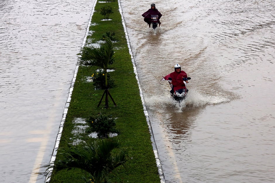 People ride motorcycles along flooded road after typhoon Damrey hits Vietnam in Hue city, Vietnam. PHOTO: REUTERS