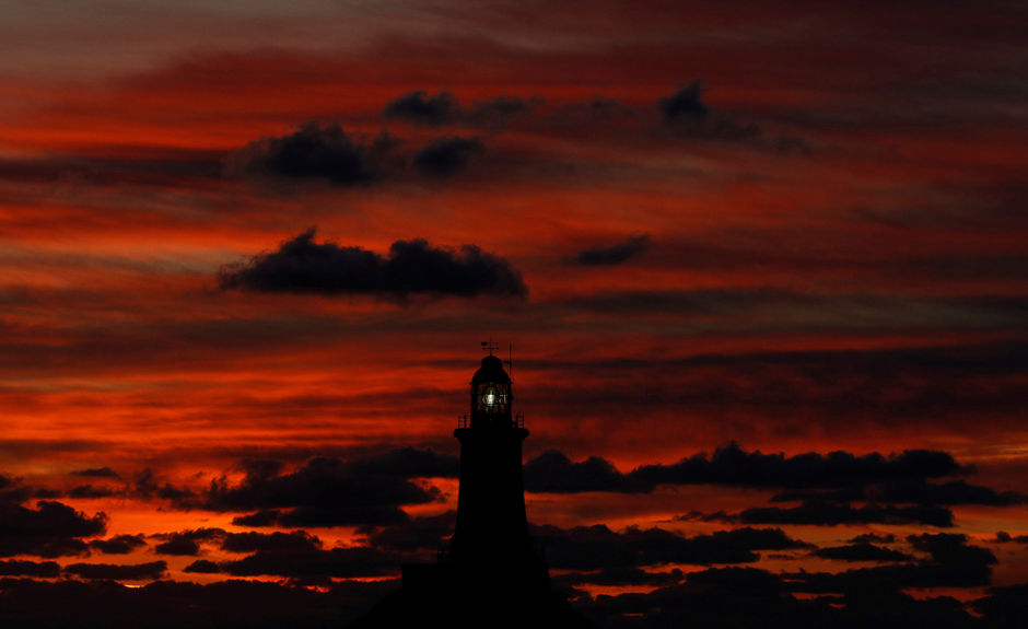 The sun sets behind La Corbiere lighthouse in Jersey, Britain. PHOTO: REUTERS