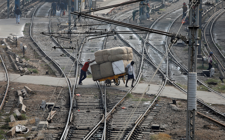 Men transport goods across railway tracks in New Delhi, India. PHOTO: REUTERS