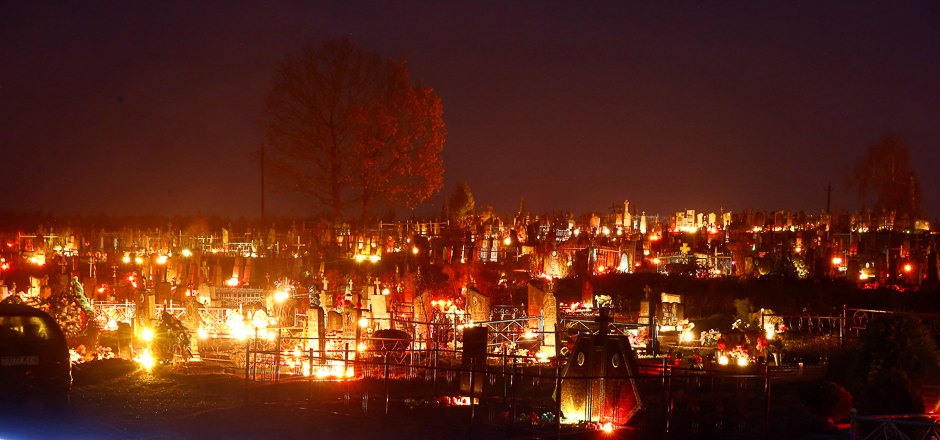 Candles placed at graves are seen during All Saints Day at a cemetery in the village of Baruny, Belarus. PHOTO: REUTERS