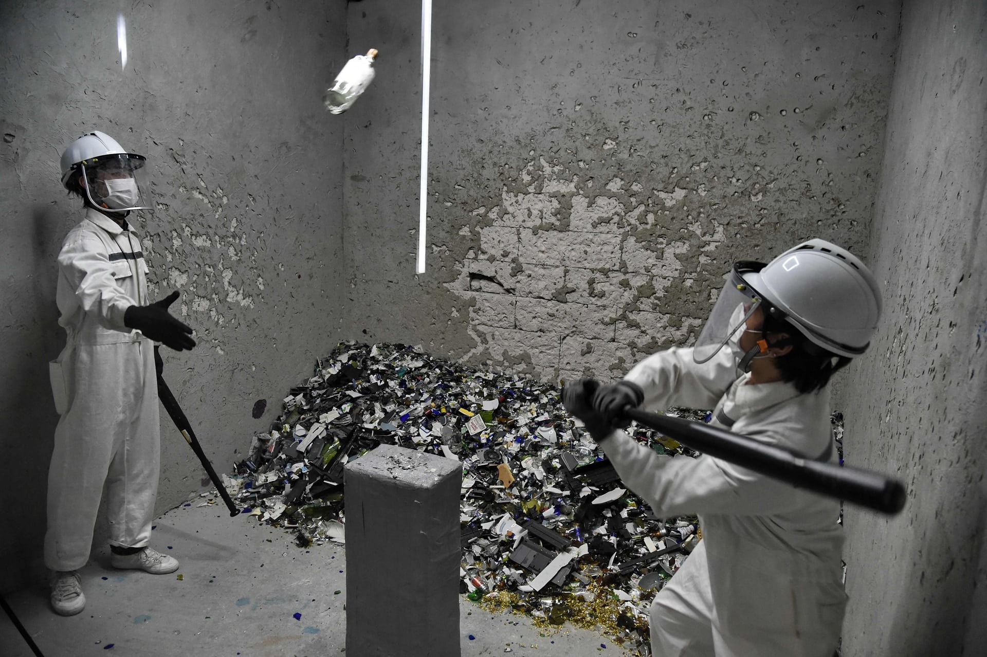 Employees smash bottles during a demonstration of a rage room, where people suffering from stress can vent their frustration in Singapore. PHOTO: AFP