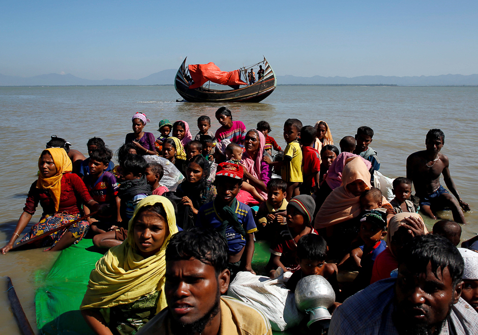 Rohingya refugees sit on a makeshift boat as they get interrogated by the Border Guard Bangladesh after crossing the Bangladesh-Myanmar border, at Shah Porir Dwip near Cox's Bazar, Bangladesh. PHOTO: REUTERS