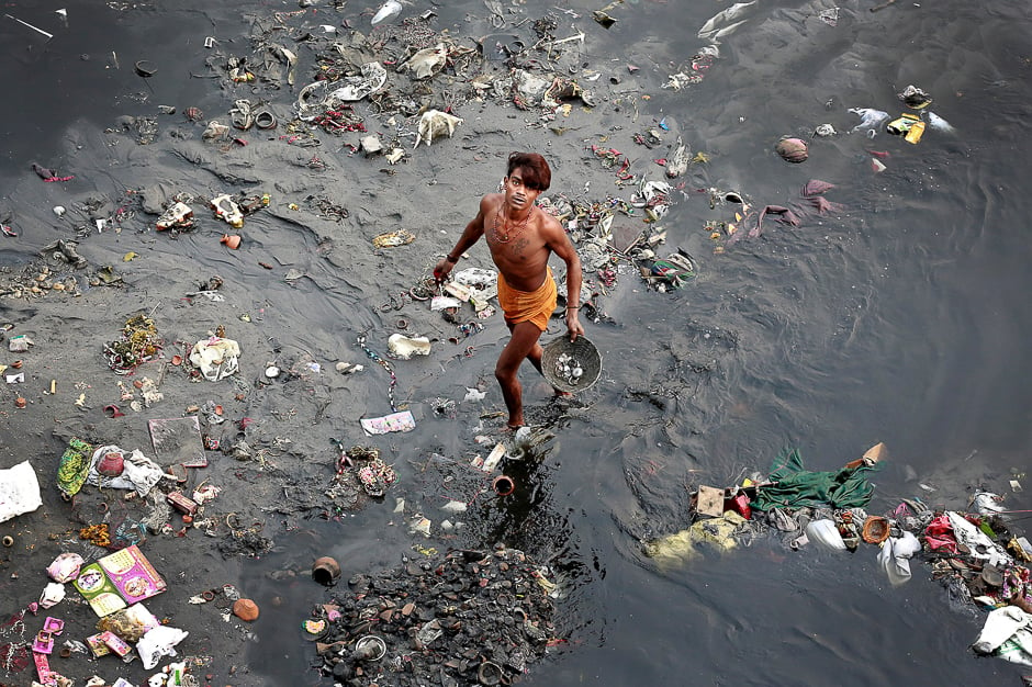 A man sifts through rubbish in the Yamuna river in Delhi, India. PHOTO: REUTERS