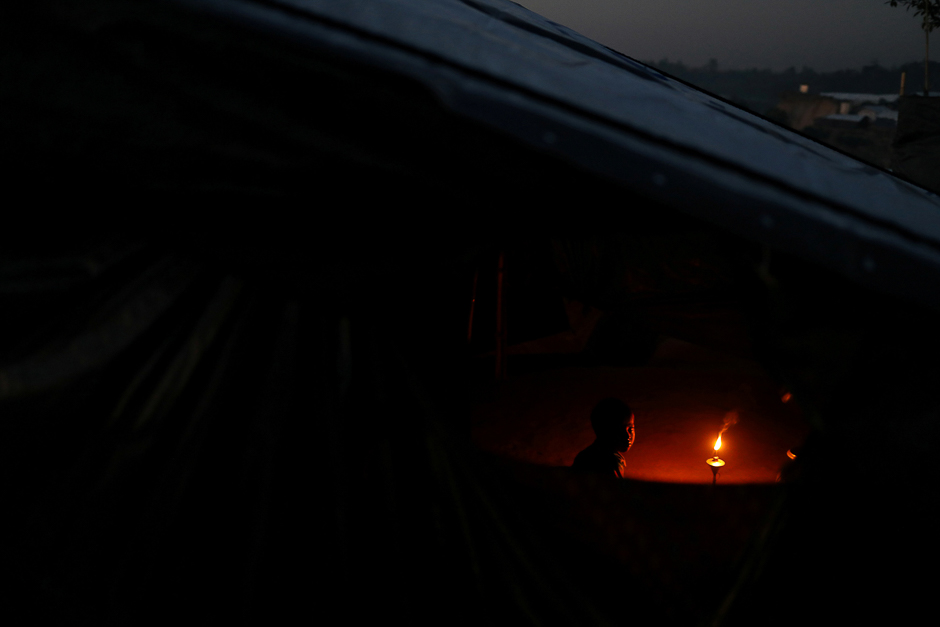 A Rohingya refugee boy waits to have dinner by candle-light at Mainnerghona refugee camp near Cox's Bazar, Bangladesh. PHOTO: REUTERS