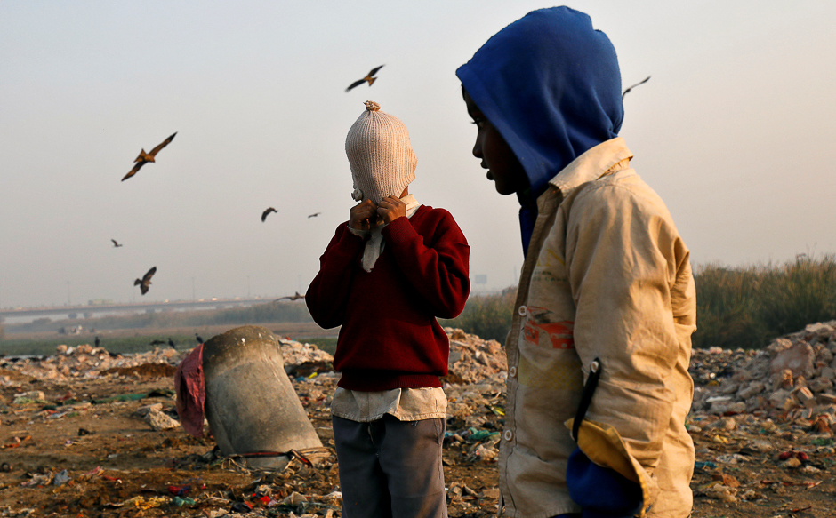 A boy covers his face with a woollen hat on the banks of the Yamuna river in Delhi, India. PHOTO: REUTERS