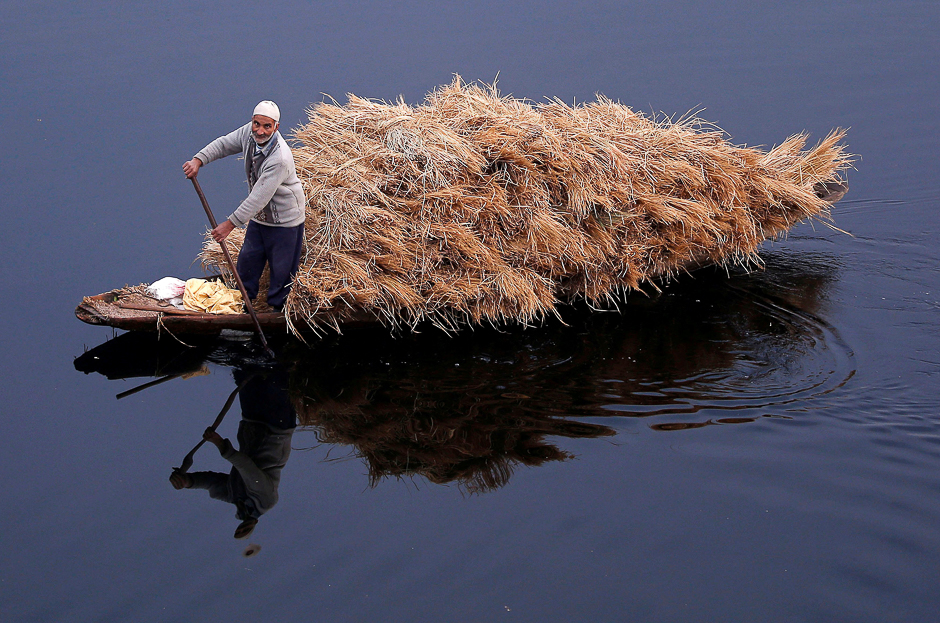 A man rows his boat filled with straw on the waters of Nageen Lake on a cold morning in Srinagar. PHOTO: REUTERS