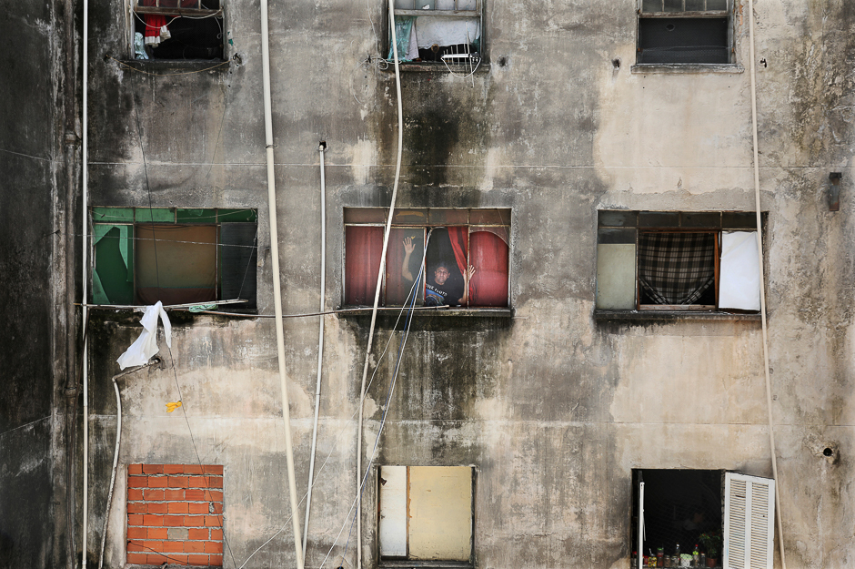 Edilson, 46, a member of Brazil's Movimento dos Sem-Teto (Roofless Movement), poses in the window of his apartament in the abandoned Santos Dumont Hotel, whose residents call themselves the 