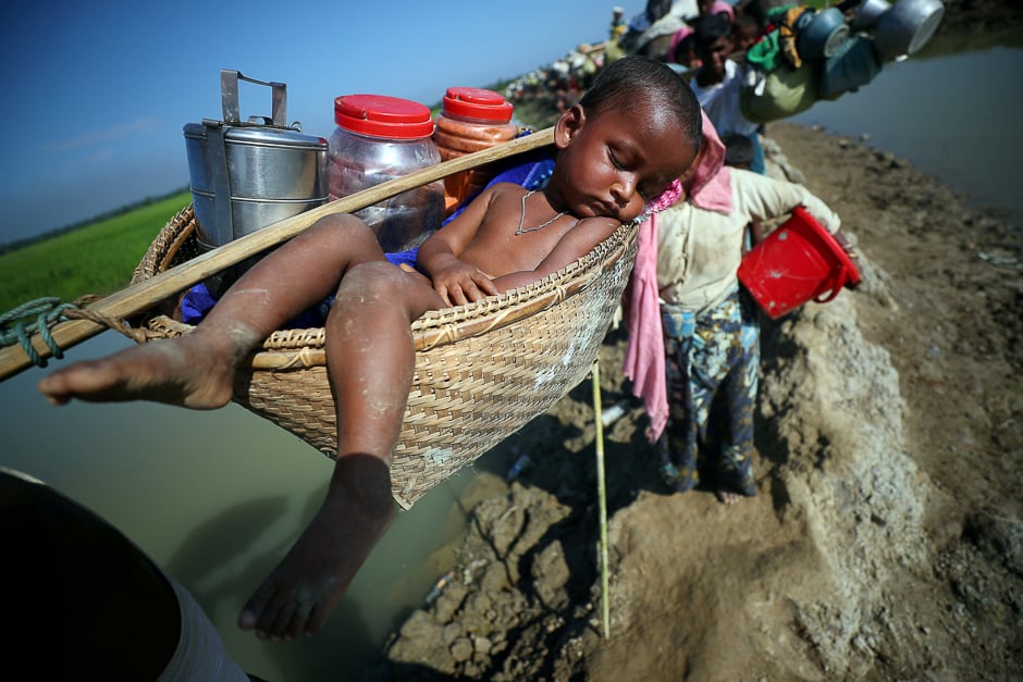 A Rohingya refugee child is carried to a refugee camp after crossing the Bangladesh-Myanmar border in Palong Khali, near Cox's Bazar, Bangladesh. PHOTO: REUTERS