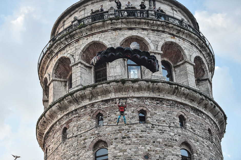 Turkish extreme sports athlete Cengiz Kocak performs a base jump off Galata Tower in Istanbul. PHOTO: AFP