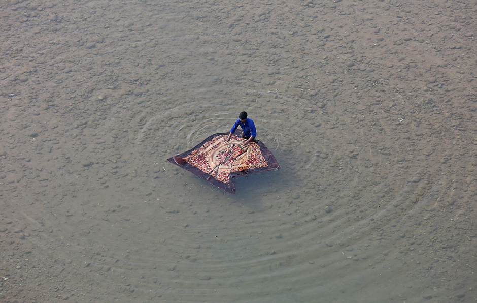 A man washes a blanket on the banks of River Tawi in Jammu. PHOTO: REUTERS