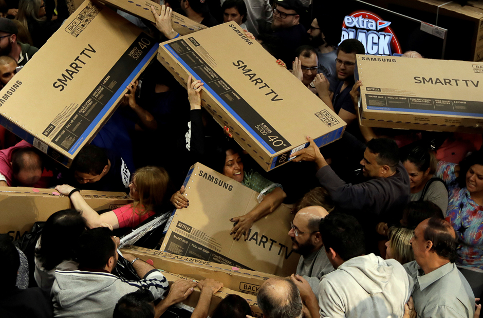 Shoppers reach out for television sets as they compete to purchase retail items on Black Friday at a store in Sao Paulo, Brazil. PHOTO: REUTERS