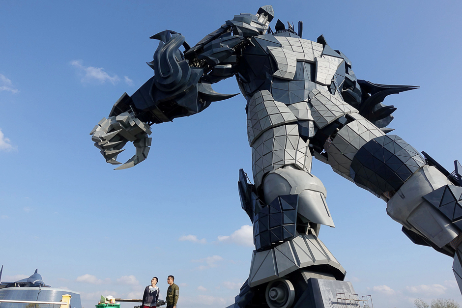 Staff members stand underneath a giant robot statue at the Oriental Science Fiction Valley theme park in Guiyang, Guizhou province, China. PHOTO: REUTERS