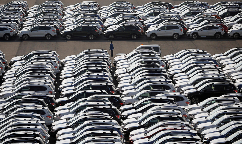 A worker is seen among newly manufactured cars awaiting export at port in Yokohama, Japan. PHOTO: REUTERS
