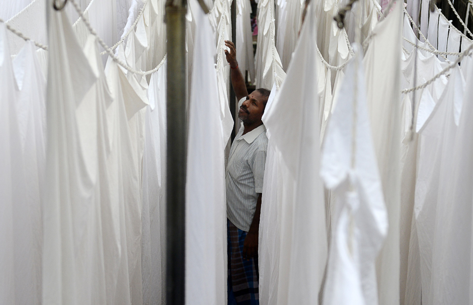An Indian laundry worker hangs freshly washed sheets at one of the city's oldest laundry facilities, or 'dhobi ghats', in Chennai. PHOTO: AFP