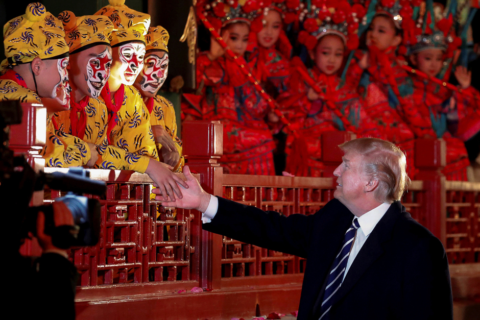 US President Donald Trump shakes hands with opera performers at the Forbidden City in Beijing, China. PHOTO: REUTERS