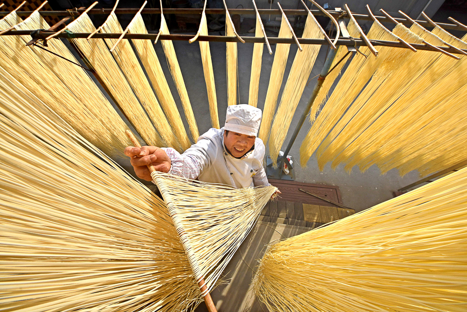 A villager hangs hand-made noodles up to dry in Linyi, Shandong province, China. PHOTO: REUTERS