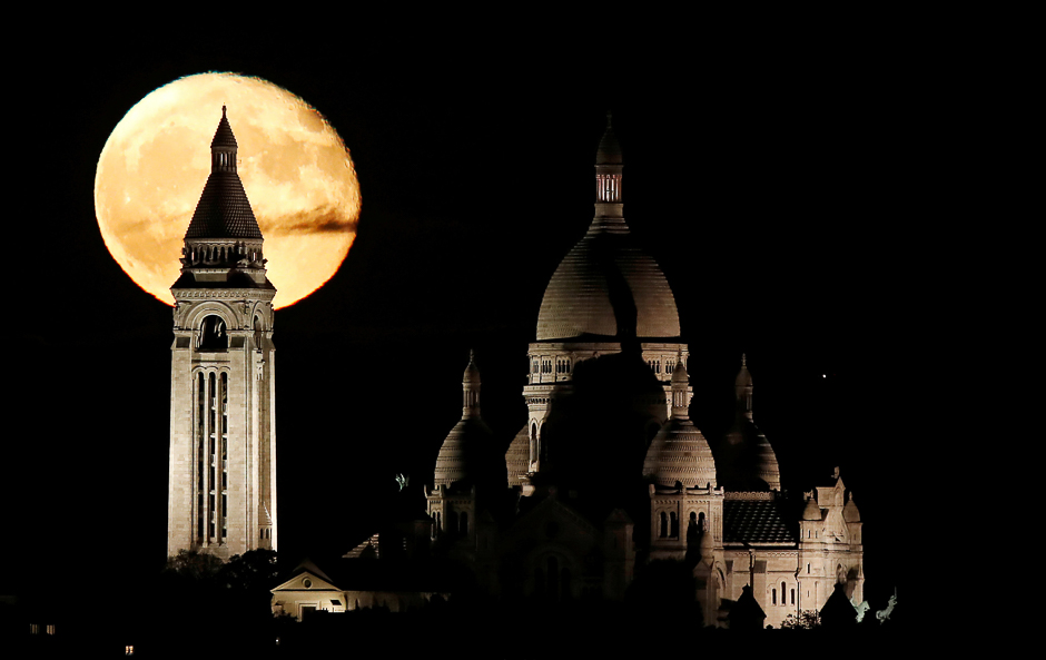 The moon rises over the Sacre Coeur Basilica in Montmartre in Paris, France. PHOTO: REUTERS