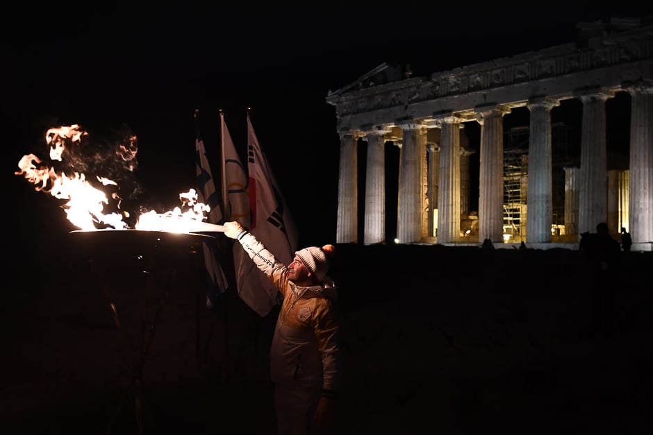 Former Olympic champion in rings Dimosthenis Tambakos lights the Olympic Flame atop the Acropolis hill in Athens during the torch relay for the 2018 Winter Olympics. PHOTO: AFP