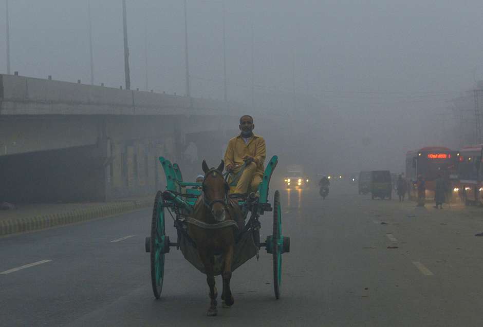A Pakistani man rides on his horse cart on a street in heavy smog in Lahore. PHOTO: AFP