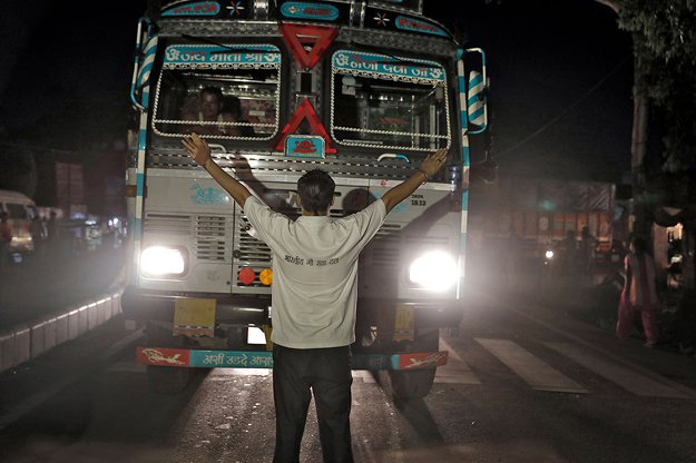 A member of the Bhartiya Gau Raksha Dal cow vigilante group raises his arms to stop a truck at a roadblock set up in the northern Indian city of Chandigarh in early July. PHOTO: REUTERS 