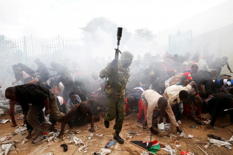 People fall as police fire tear gas to try control a crowd trying to force their way into a stadium to attend the inauguration of President Uhuru Kenyatta at Kasarani Stadium in Nairobi, Kenya. PHOTO: REUTERS