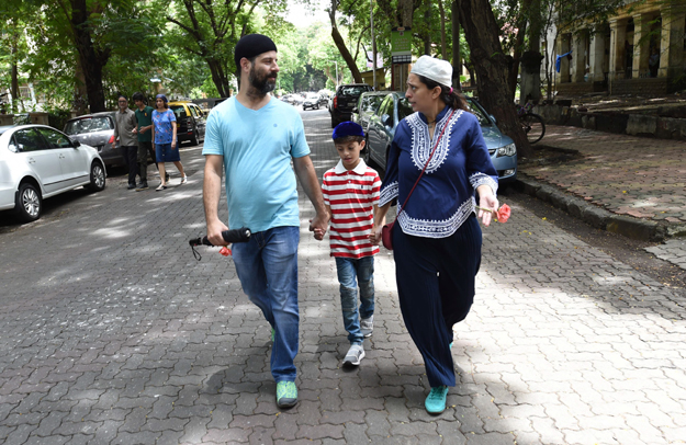 This picture shows Indian Parsi Pearl Tirandaz (R), six months pregnant with her second child, talking with her husband Darius while walking back home from a Fire Temple after offering prayers in Mumbai. PHOTO: AFP