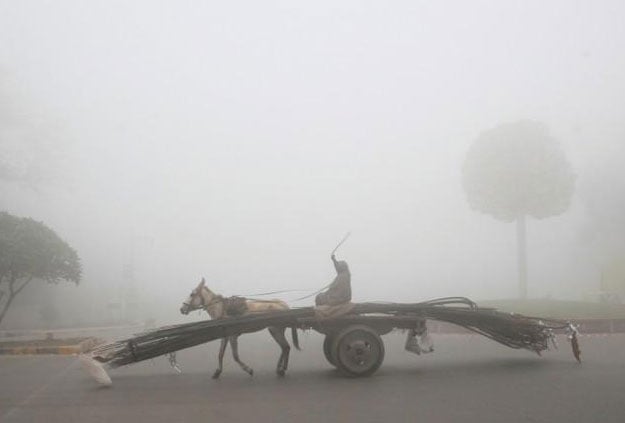 A man rides a donkey-drawn cart supplying steel rods on a smoggy morning in Lahore. November 10, 2017. PHOTO: REUTERS