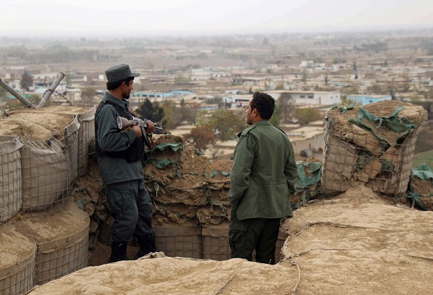  Afghan police officers keep watch at their forward base on the outskirts of Kunduz province, Afghanistan. PHOTO: REUTERS